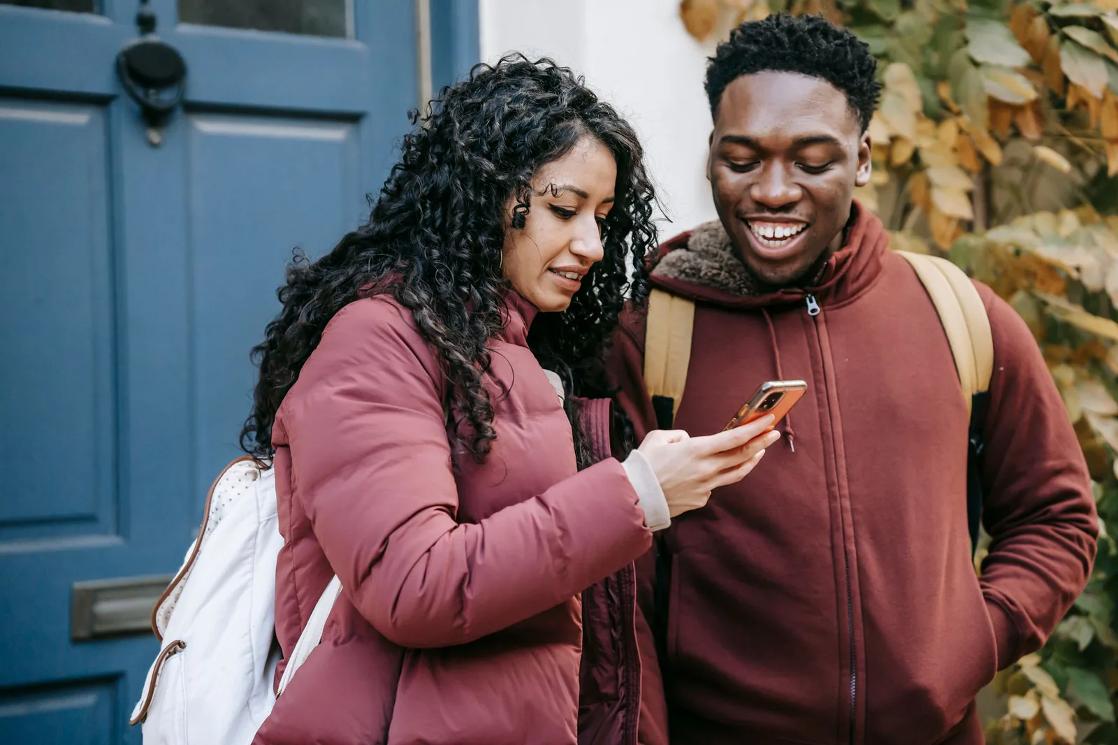 A couple looking at a phone together on a city street