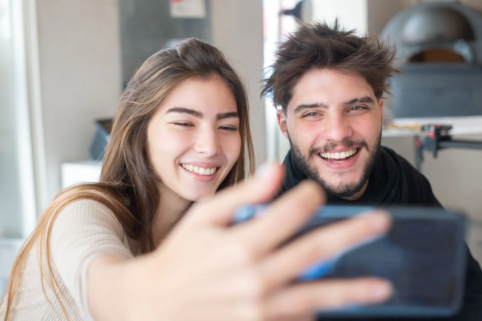 A happy young couple taking a selfie together at home