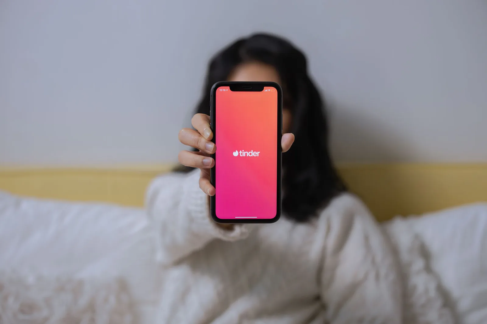 Person holding a phone with a dating app open on the screen